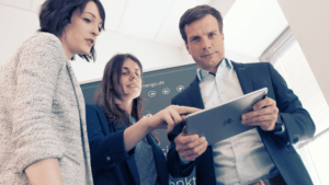 Drei Mitarbeiter am mobilen Endgeraet Tablet