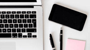 Arbeitsplatz Ausschnitt mit Smartphone, Laptop, Stiften