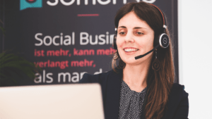 Somengo Mitarbeiterin remote mit Headset und Laptop