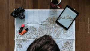 Urlaubsplanung mit Landkarte Tablet und Kamera