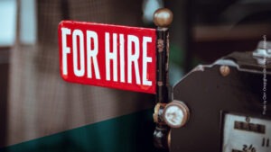 Kleines, rotes Schild mit der Aufschrift "For Hire"