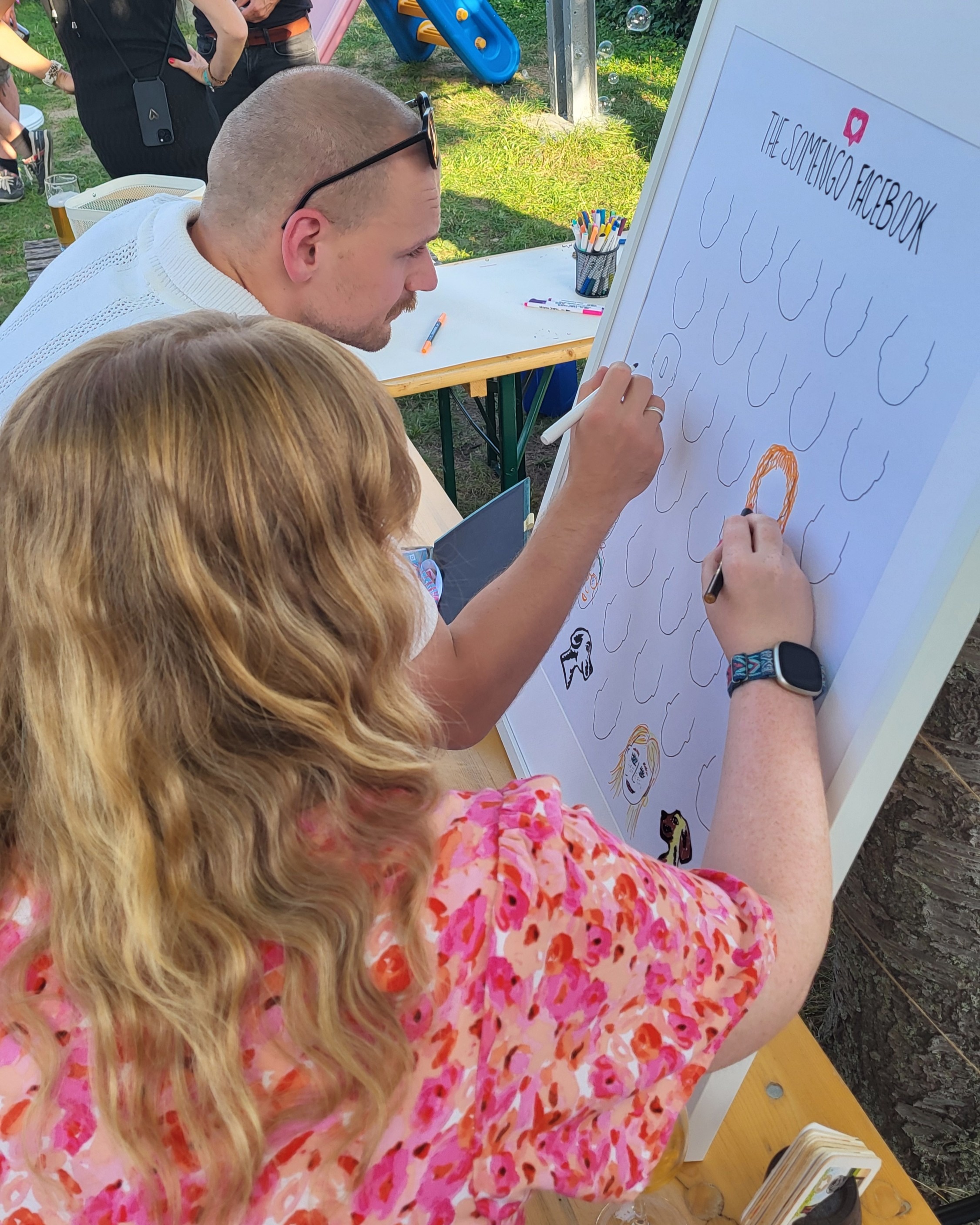 Somengos malen ihre Gesichter auf analoges Facebook-Plakat