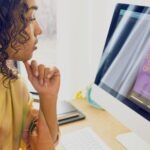 Frau arbeitet an PC mit Canva-Programm