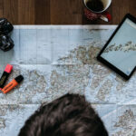 Urlaubsplanung mit Landkarte Tablet und Kamera