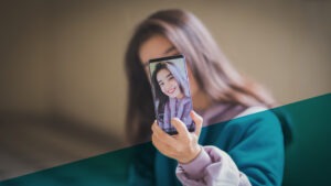 Junge Frau mit braunen Haaren macht Selfie