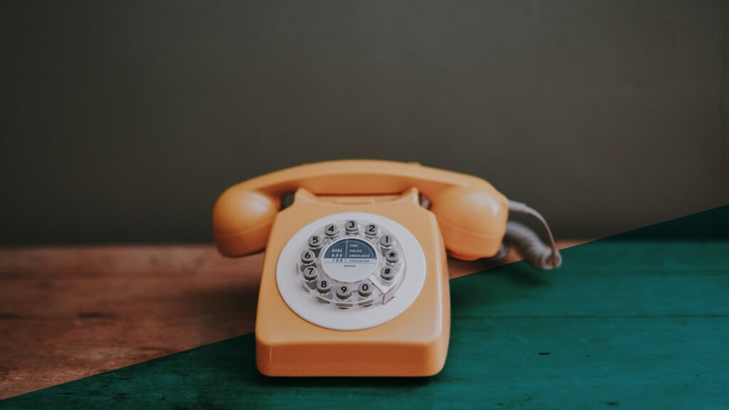 Altes Telefon mit Wählscheibe auf Holztisch