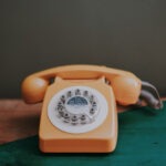 Altes Telefon mit Wählscheibe auf Holztisch