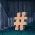 Großes Hashtag-Symbol aus Holz vor einer Wellblech-Wand platziert