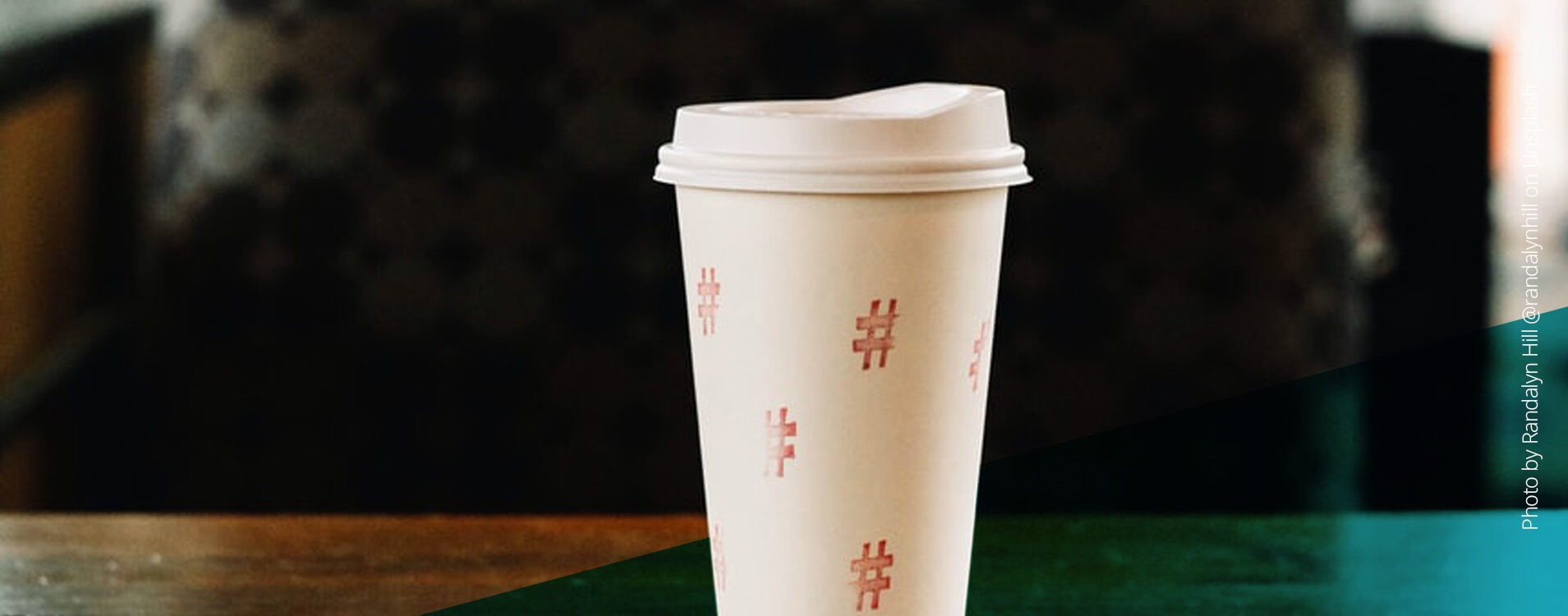 Weißer Kaffee To-Go-Becher mit aufgemalten Hashtags
