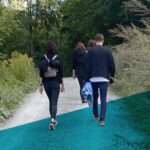 Vier Personen laufen einen Waldweg entlang
