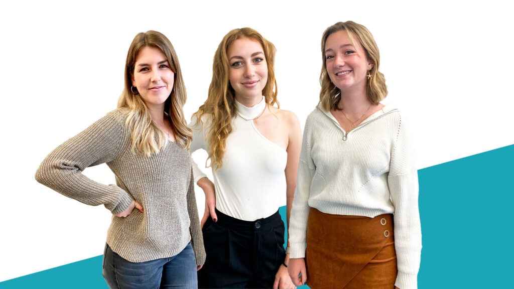 Drei junge Frauen mit blonden Haaren lächeln in die Kamera