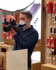 Man mit Kamera filmt in einen Laden